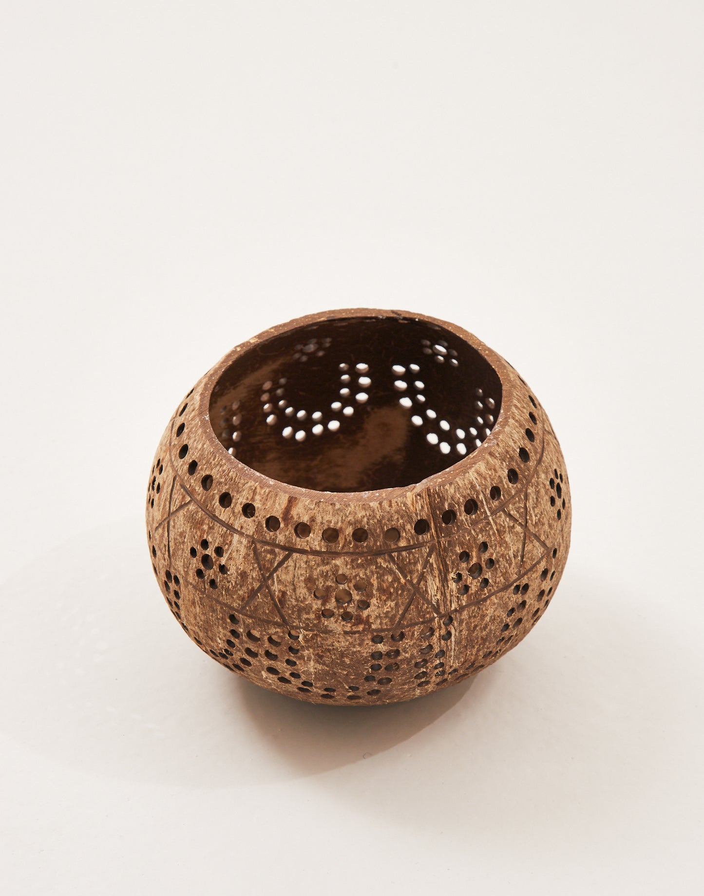 Coconut candle holder with perforations